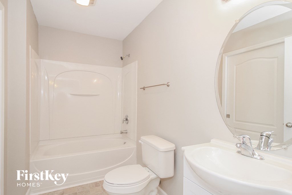 a white bathroom with a white toilet and a tub and a sink