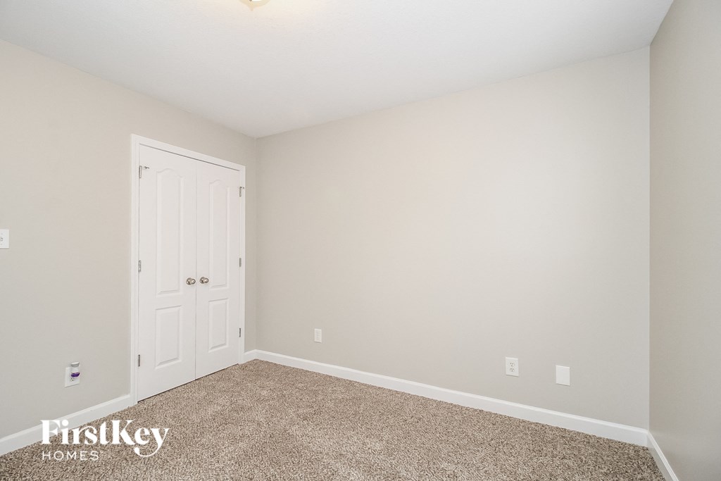 a bedroom with a carpeted floor and a white door