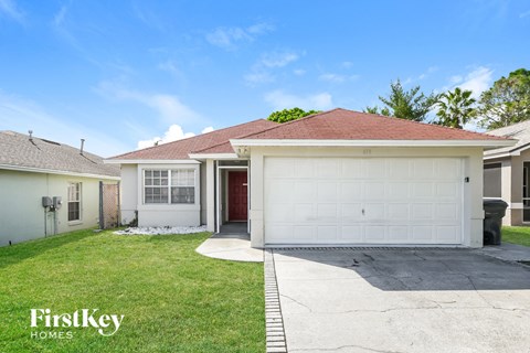 a home with a white garage door and a lawn