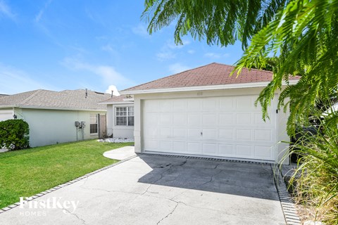 a home with a white garage door and a lawn