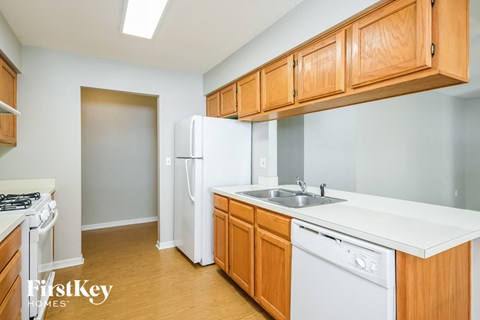 a kitchen with white appliances and wooden cabinets
