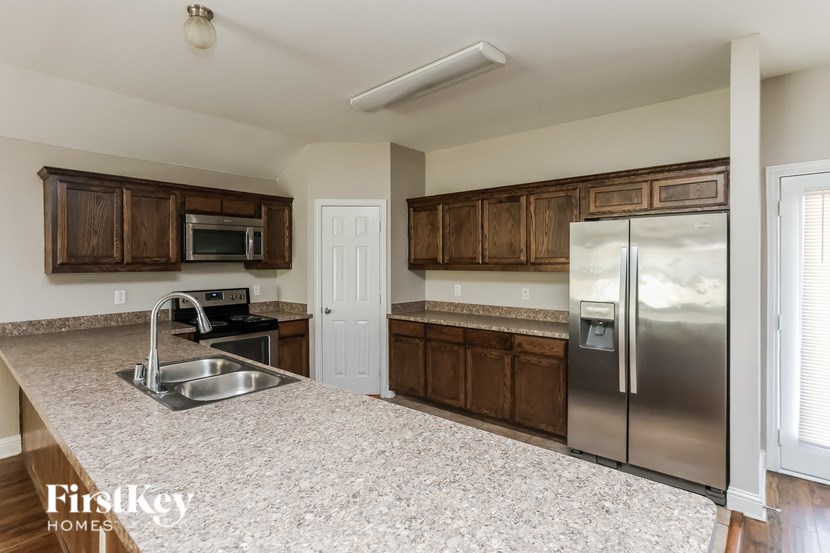 A kitchen with a sink, stove, and refrigerator.