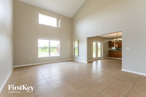 A spacious room with a tile floor and a large window.