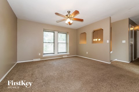 the master bedroom is spacious and updated with carpeting and a ceiling fan