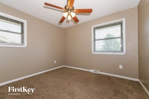 the master bedroom has a ceiling fan and beige carpet