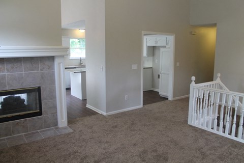 A living room with a fireplace and a baby crib.