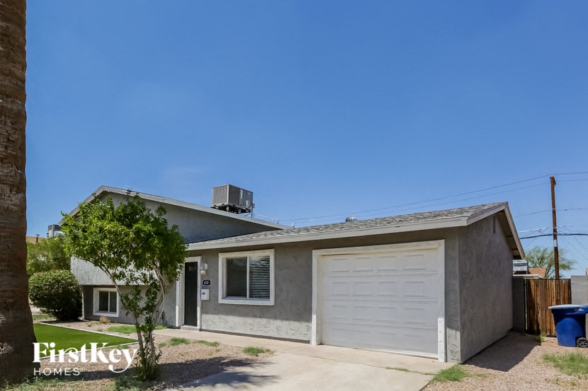 a small gray house with a white garage door