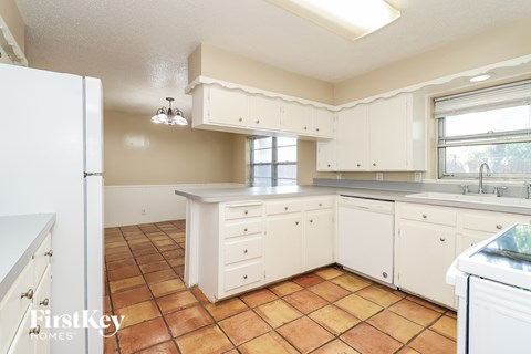 A kitchen with white appliances and cabinets.