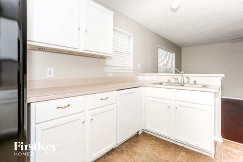 A kitchen with white cabinets and a sink.