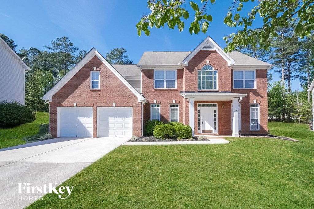 A brick house with a white garage door and a white front door.