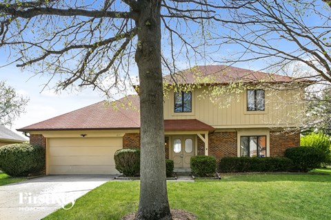 A house with a tree in front of it.