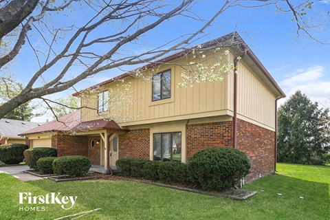 A house with a yellow exterior and a red roof is for sale by FirstKey Homes.