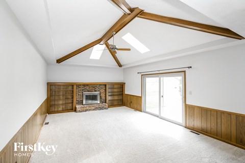 A spacious room with a fireplace and a ceiling fan.