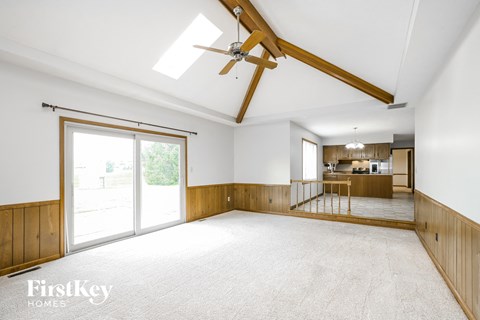 A spacious room with a ceiling fan and sliding glass doors.