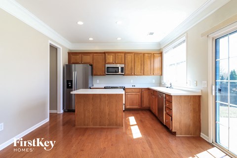 A kitchen with wooden cabinets and a refrigerator.