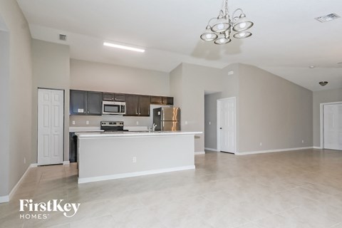 an open kitchen and living room with a white counter top