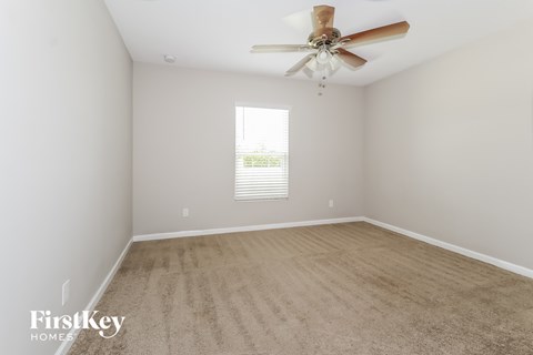 a spacious room with a ceiling fan and a carpet