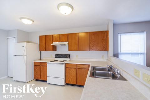 A kitchen with wooden cabinets and a white fridge.