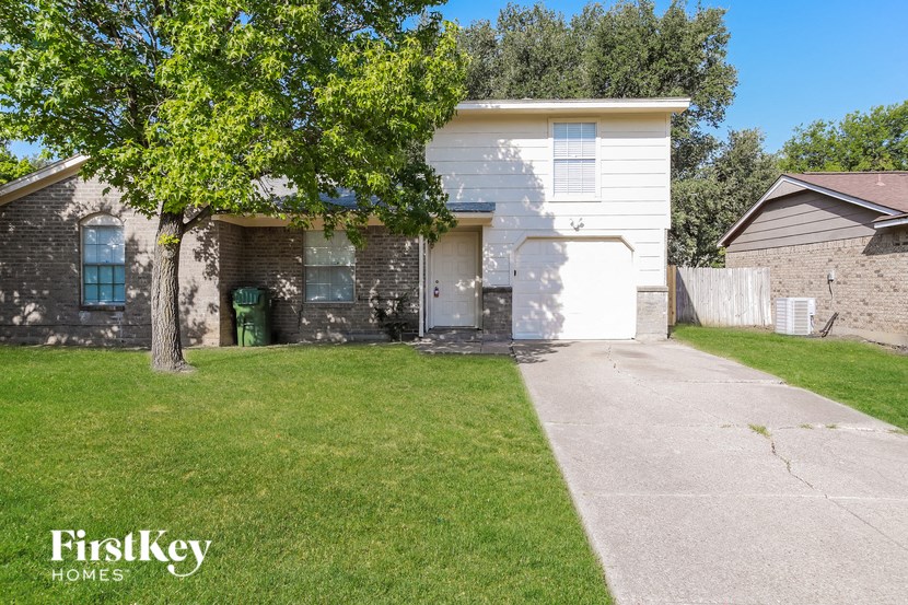 a white house with a yard and a tree