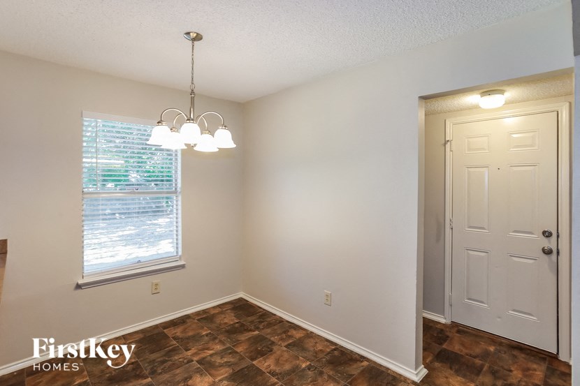 an empty bedroom with a window and a white door