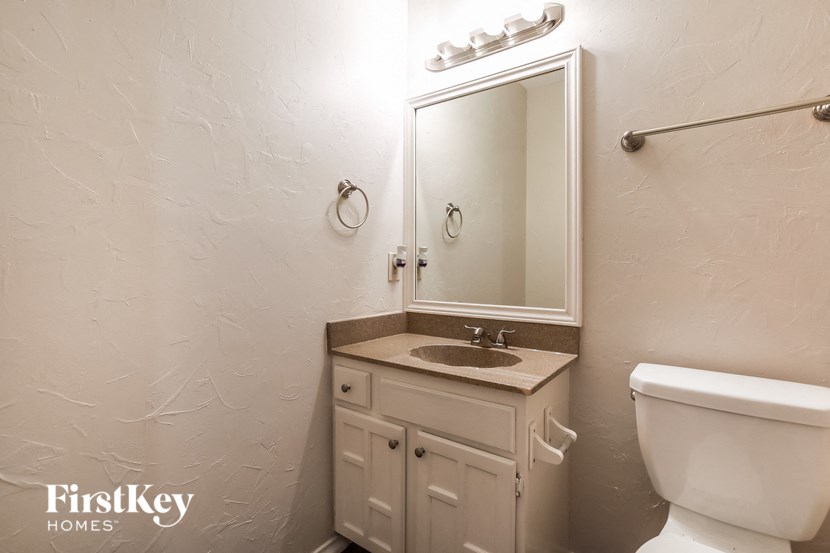 a bathroom with a toilet sink and a mirror