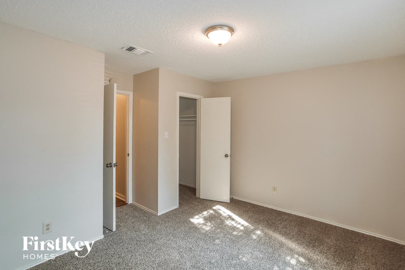 a empty room with white walls and a door to a closet