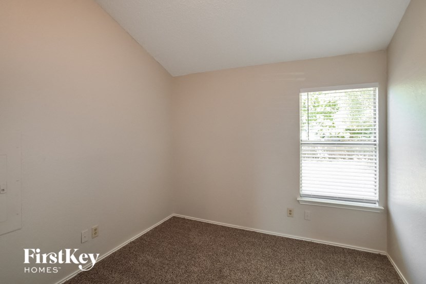 the bedroom of a home with a window and carpet