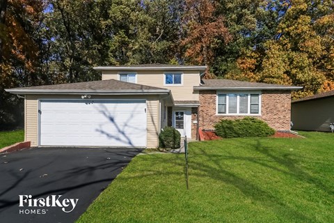 a home with a white garage door and a lawn