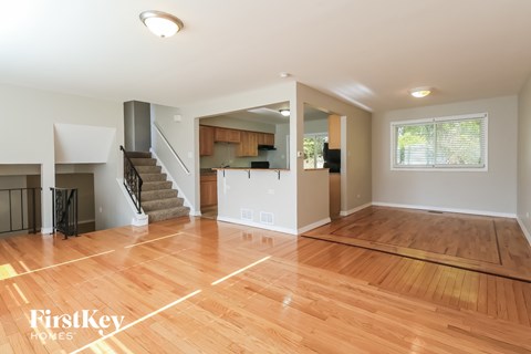 an empty living room with a hard wood floor and a staircase