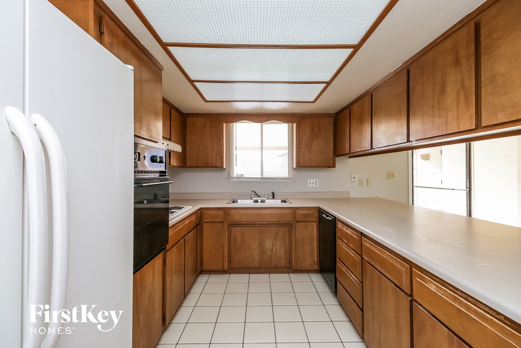 A kitchen with wooden cabinets and a white refrigerator.