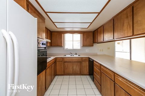 A kitchen with wooden cabinets and a white refrigerator.