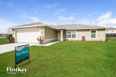 a home with a lawn and a sign in front of it