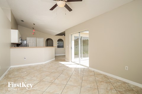 an empty living room with a sliding glass door to the kitchen