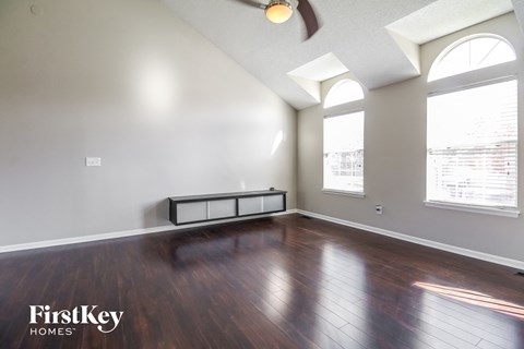 the living room with hardwood flooring and large windows