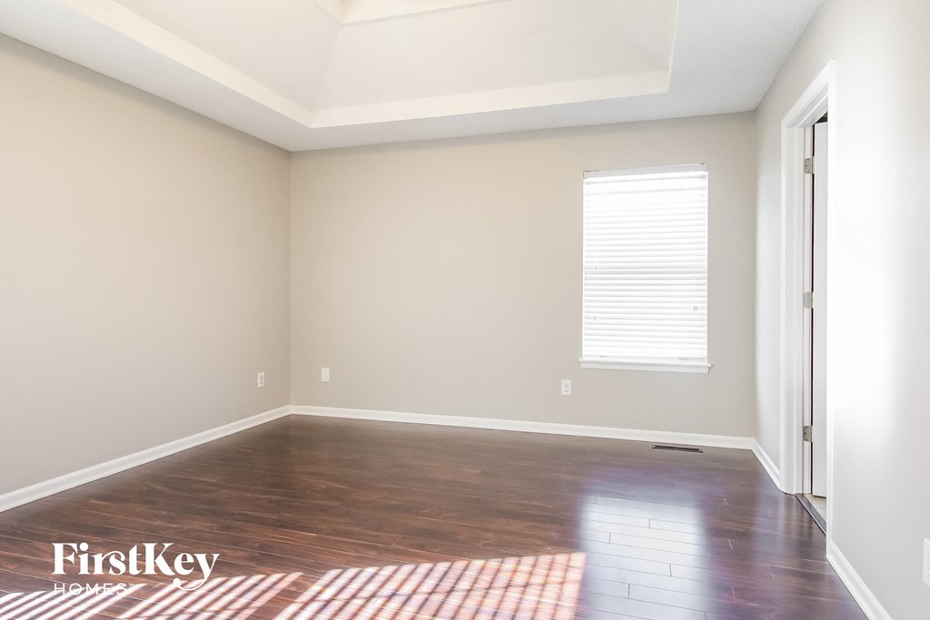 an empty room with wood floors and a window