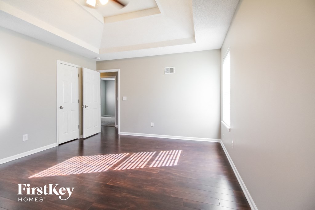 an empty living room with wood floors and white walls