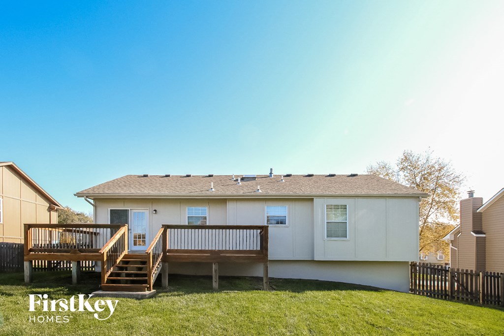 a small white house with a deck and a porch