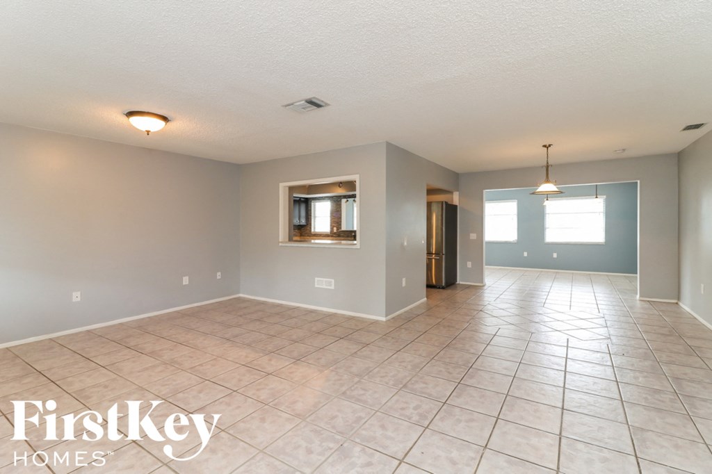 A spacious room with tile flooring and a large window.