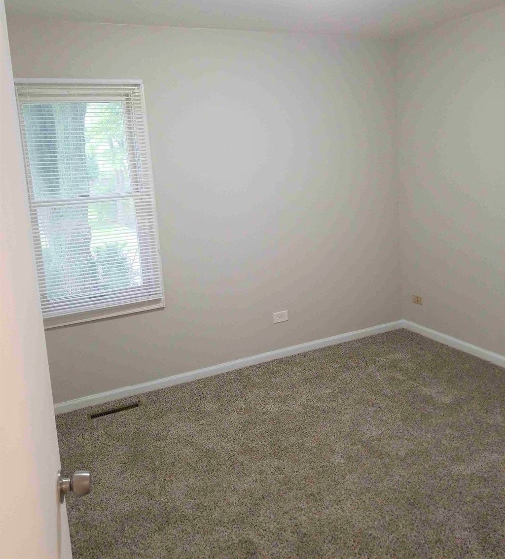 a room with a carpeted floor and a window