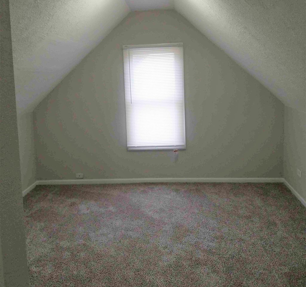 an empty room with carpet and a window