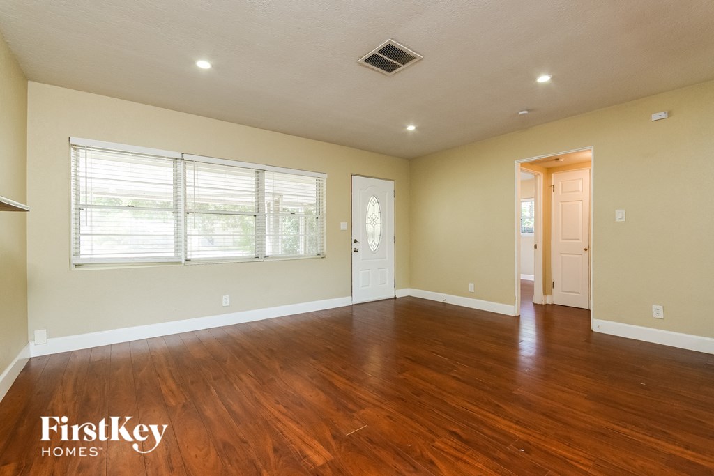 A spacious room with wooden floors and a white ceiling.
