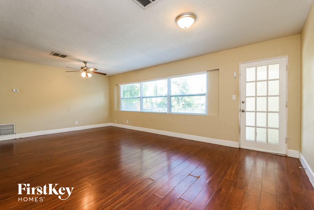 A room with wooden floors and a ceiling fan.
