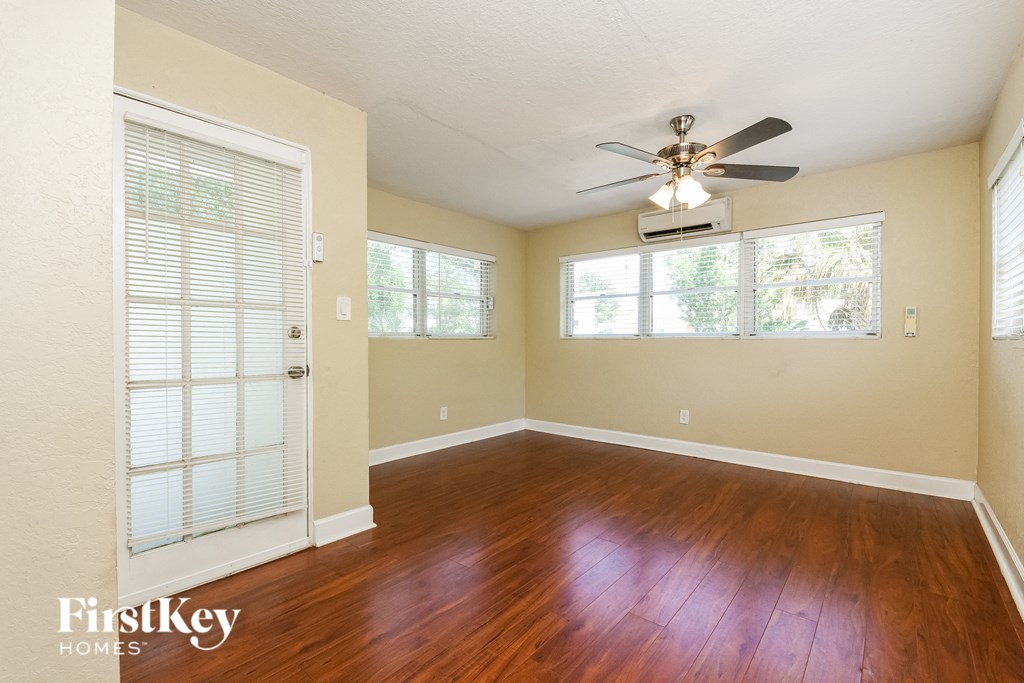 A room with a ceiling fan and wooden floors.