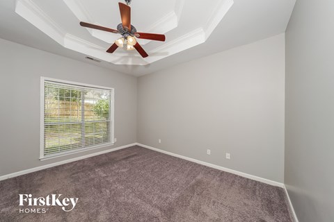 the living room has a ceiling fan and a carpet
