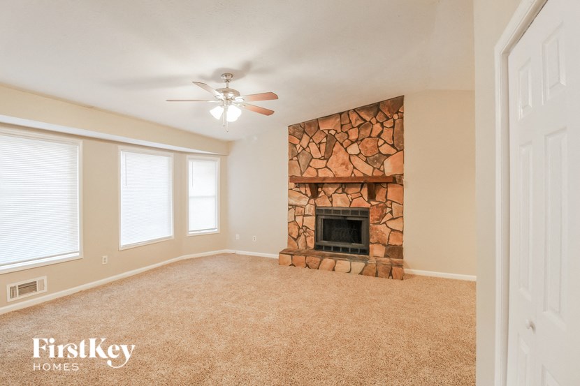 a living room with a fireplace and a ceiling fan
