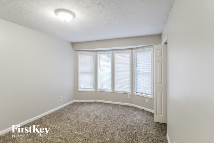 an empty room with four windows and a door