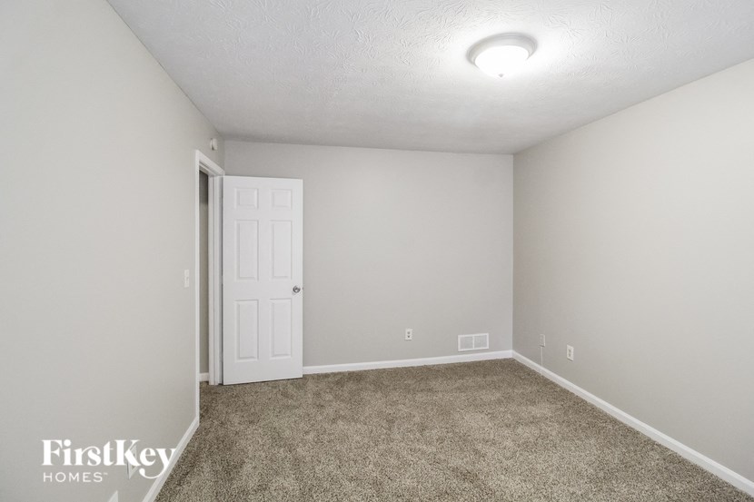 a room with a carpeted floor and a white door