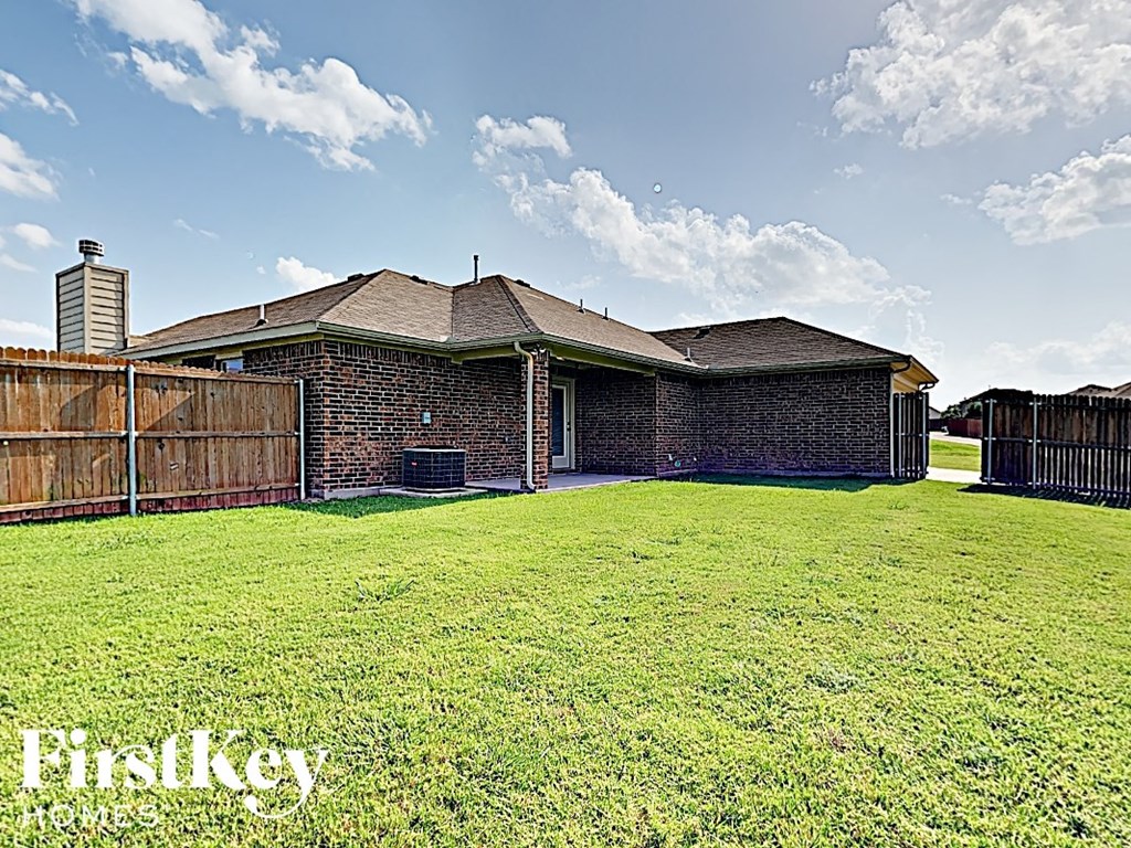A house with a fence and a grassy yard.