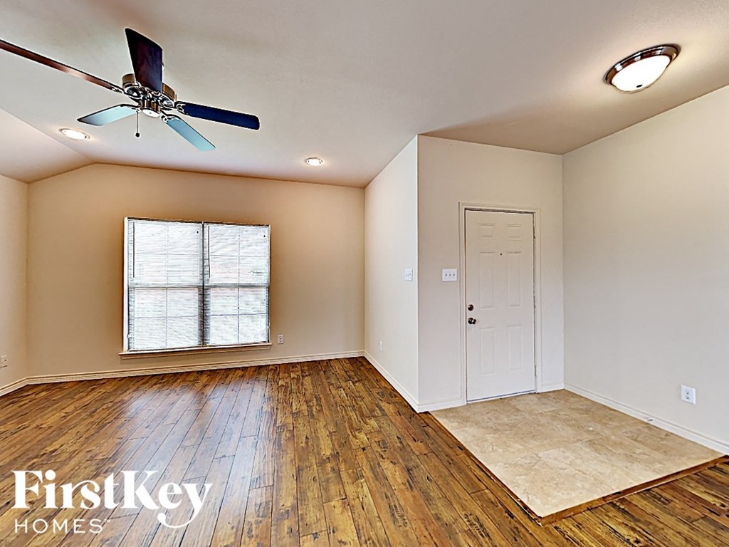 A room with a fan and a window.