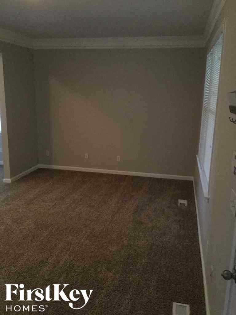 A room with a carpeted floor and a door on the right side.